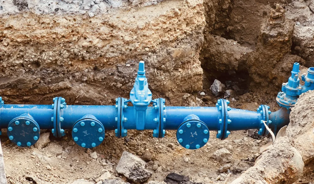 Plumber inspecting exposed pipe for corrosion