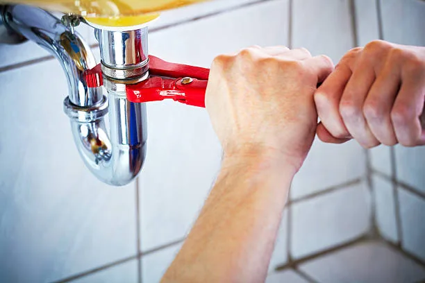 Close-up of a plumber tightening a pipe connection to stop a leak